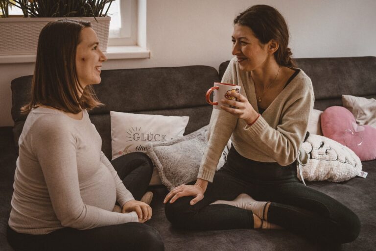Yogadoula Jelena Drofenik auf der Couch sitzend, im Gespräch mit einer schwangeren Frau